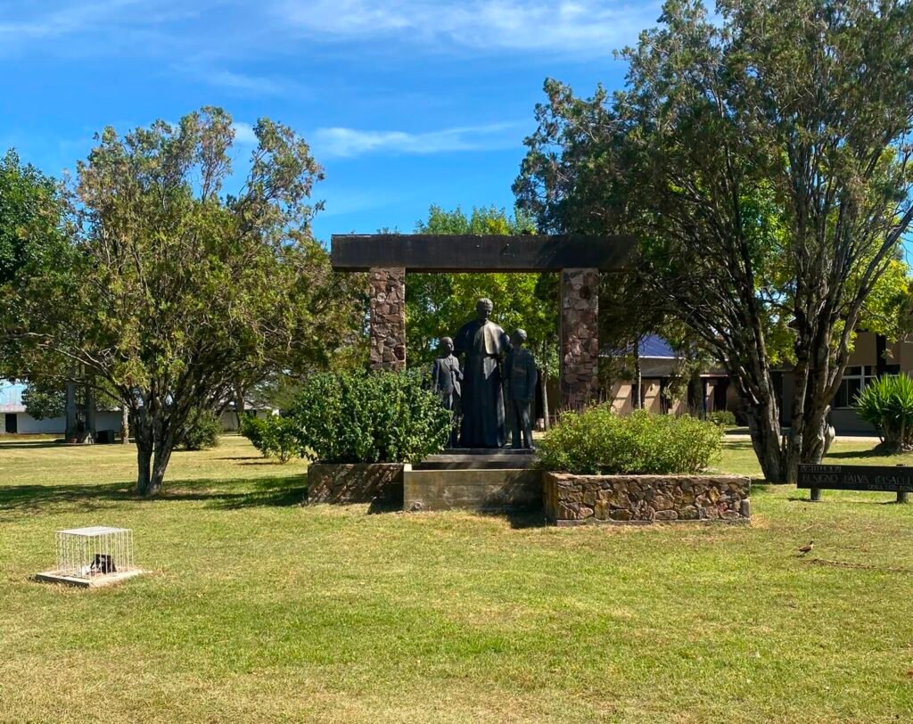 Imagen de Don Bosco y sus jóvenes en la entrada de la institución
